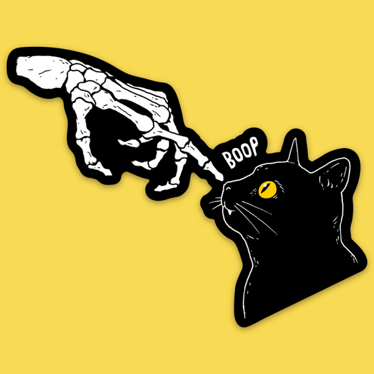 Vinyl sticker featuring skeletal hand booping a black cat with yellow eyes against yellow background, text reads 'BOOP'