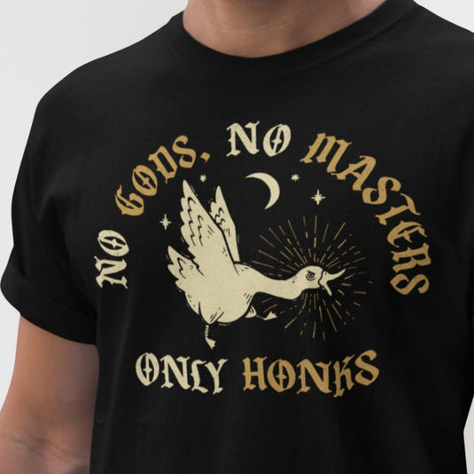 Black graphic tee with cream dove and gold text reading 'No Gods, No Masters, Only Honks' on dark background with moon and
