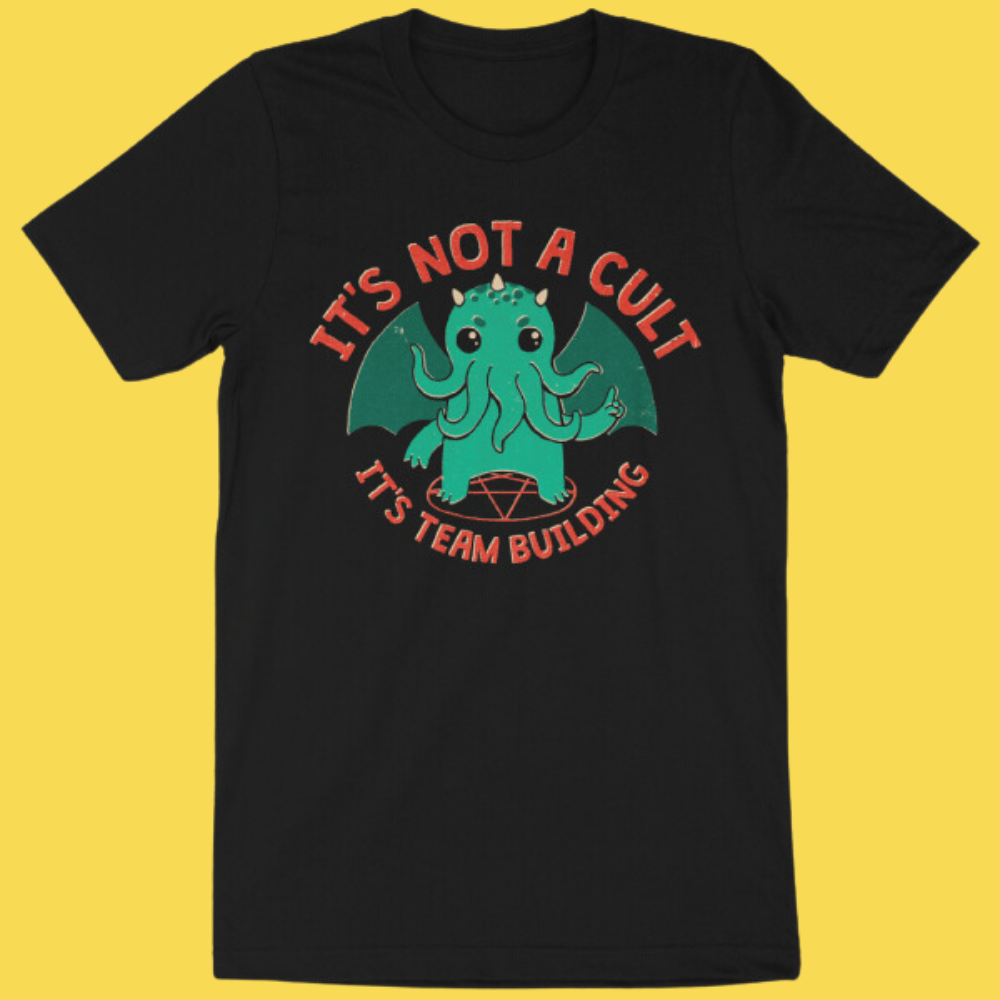 Black graphic tee featuring a cute green Cthulhu with 'It's Not a Cult It's Team Building' text on yellow background.