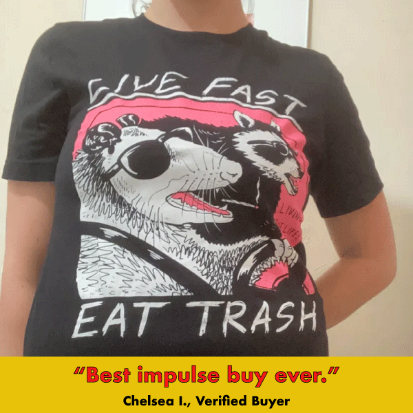 Black graphic tee with bold white and pink raccoon illustration and 'Live Fast Eat Trash' text design