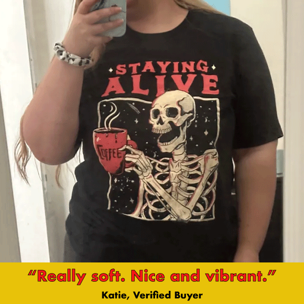 Black graphic tee featuring skeleton holding coffee cup with 'Staying Alive' text in gothic style design