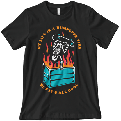 Graphic t-shirt of a skeleton doing a skateboard trick over a flaming dumpster with text that reads "my life is a dumpster fire but it's all cool"
