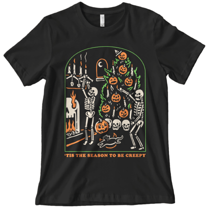 A black graphic tee with skeletons decorating a Christmas tree with pumpkins and skulls with text that reads tis the season to be creepy